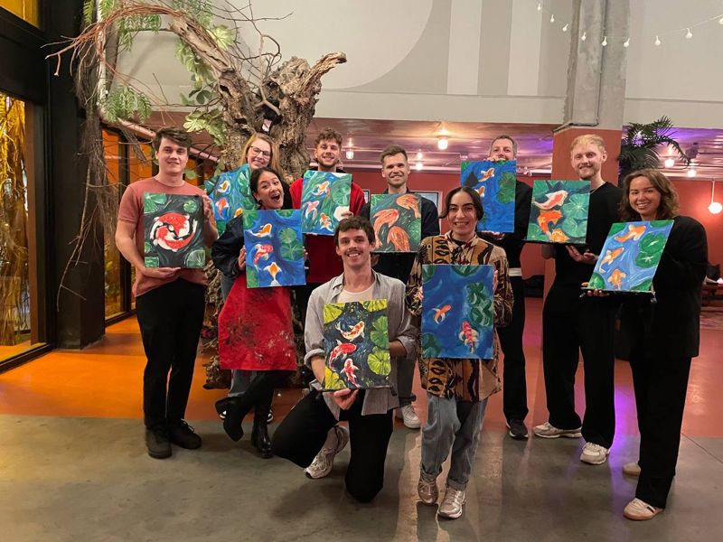 Een team met hun schilderijen in Foodhallen Rotterdam